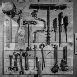 Black-and-white photo of tools hanging on a wall
