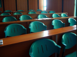 Tiered rows of green plastic chairs in a classroom
