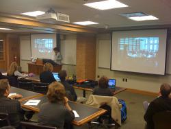 Teacher standing in front of classroom with projector screens