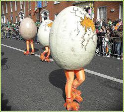 Three people on the street in egg costumes with legs