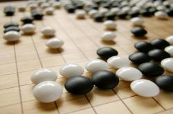 Black and white game pieces on a wooden board