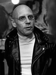 Black and white photo of Michel Foucault in a leather jacket