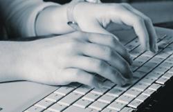 Black and white photo of hands typing